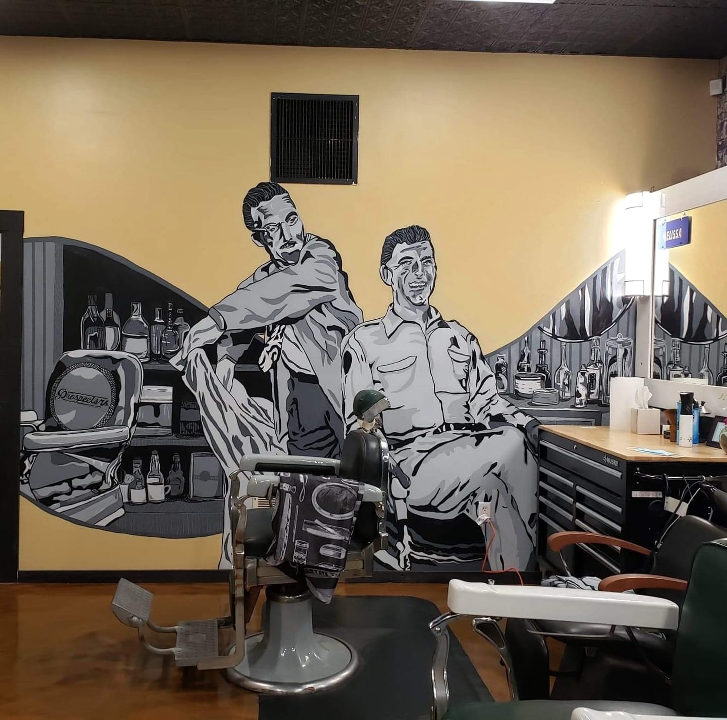 Vintage barbering mural and barber chairs inside Skyland Barber Shop